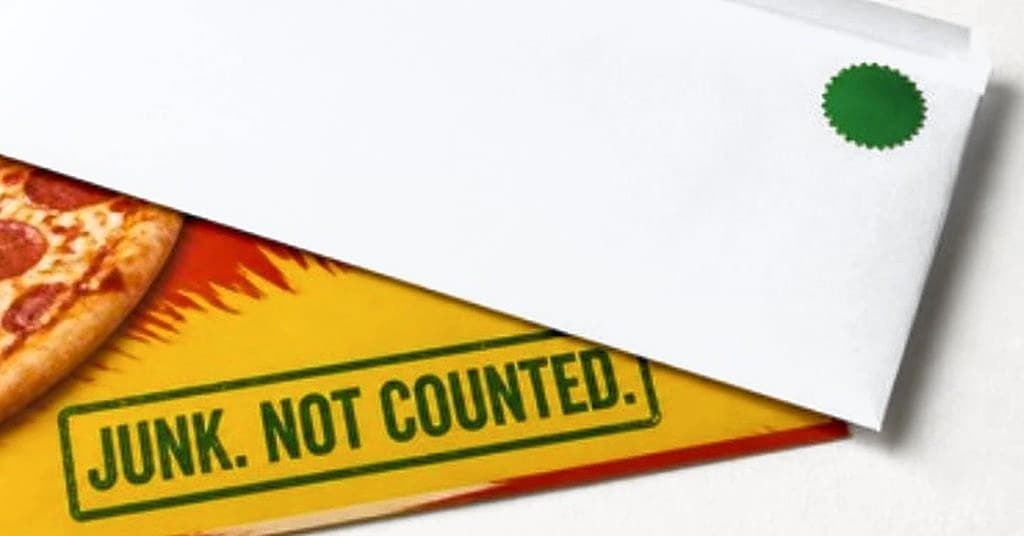 Your envelope with our green seal, lying on a pizza flyer stamped Junk. Not counted.